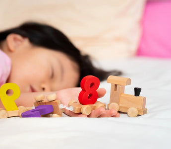 Slapend kind met educatief speelgoed – slaap bevordert leerontwikkeling en geheugen na spelen.